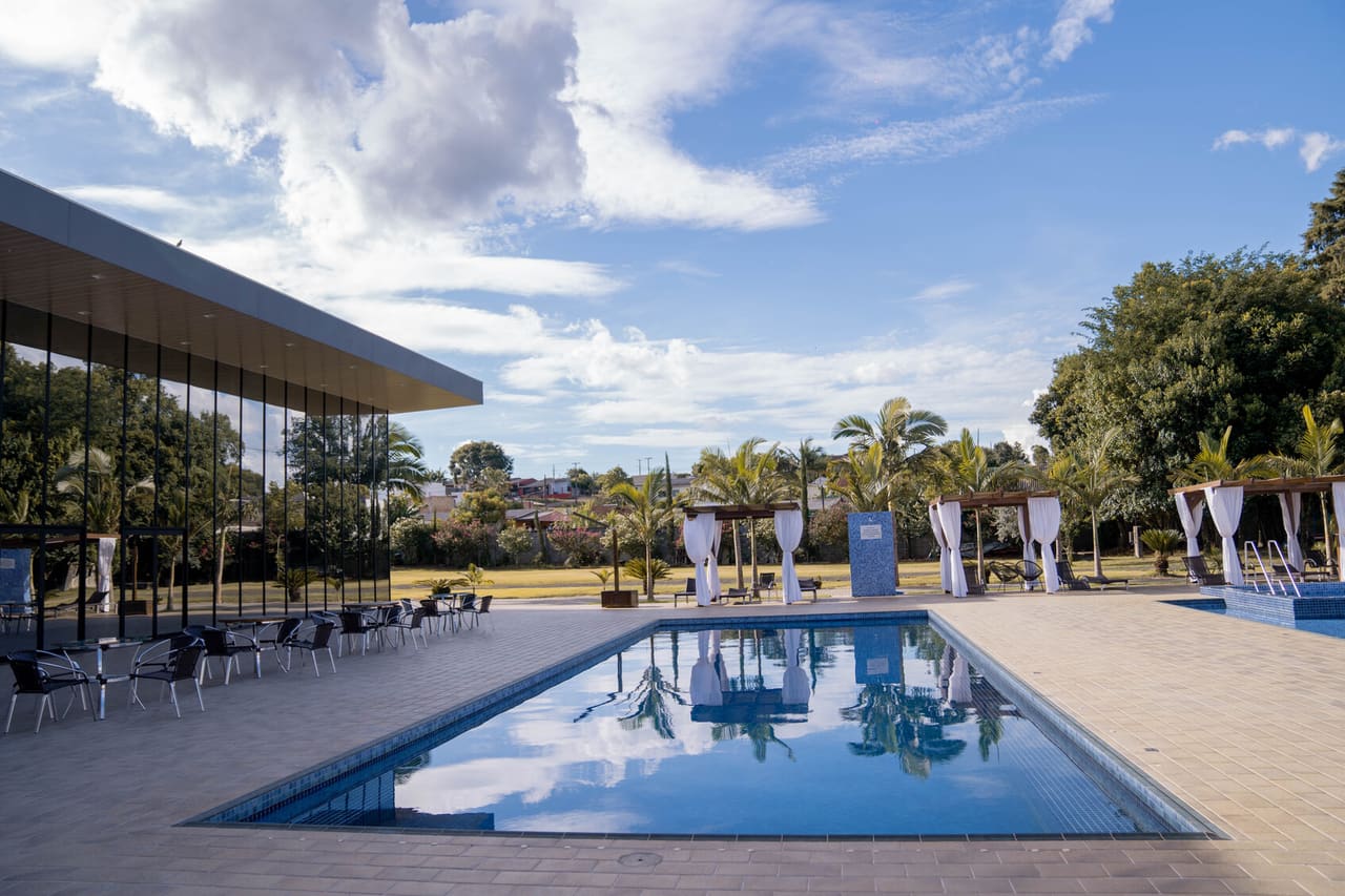 Piscina externa com vista para o jardim e estrutura envidraçada
