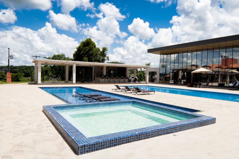 Piscina externa com jacuzzi integrada e espreguiçadeiras